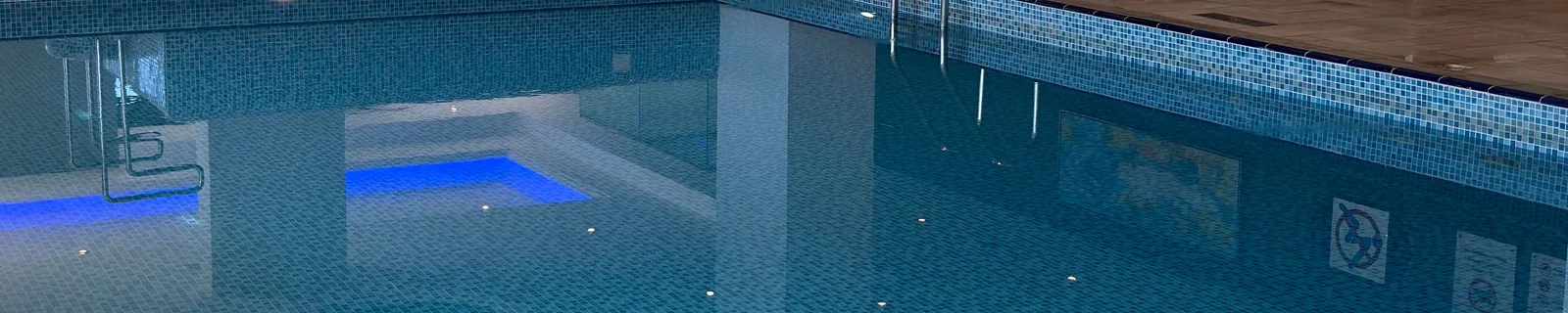 Innenpool mit Liegebereich in einem Wellnessbetrieb